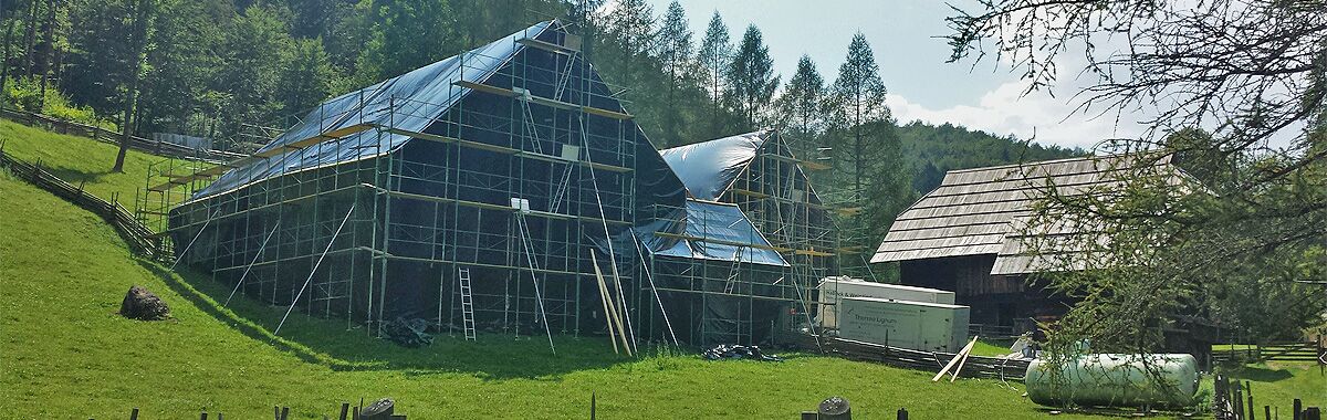 Bâtiment historique dans un musée en plein air en Styrie pendant un traitement thermique par Thermo Lignum – enveloppement hermétique et échafaudage extérieur